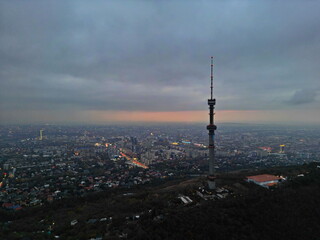 Naklejka premium Koktobe TV tower on the hill after sunset. View of the city. Cloud cover. Autumn.