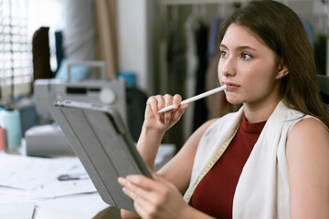 Creative designer thinking and using digital tablet working to sketch and draw in the office