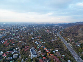 Obraz premium View of the city, with different buildings and streets. Sunset time. Autumn. The view from the drone.