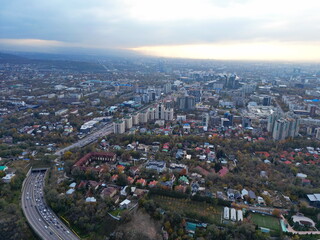 Fototapeta premium View of the city, with different buildings and streets. Sunset time. Autumn. The view from the drone.