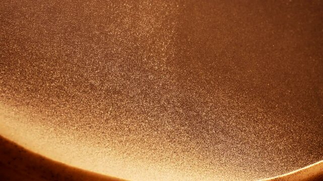 Golden sand particles flowing in slow motion. Abstract macro shot. 