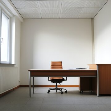 A small office with a wooden desk and chair. The chair is brown and has a leather back