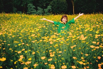 Person Spreading Arms in a Field of Blooming Yellow Cosmos