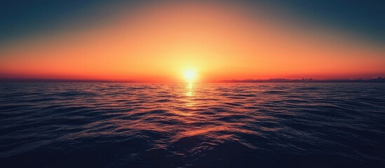 Obraz premium Sunset Over The Horizon Of The Ocean With Cloudless Sky