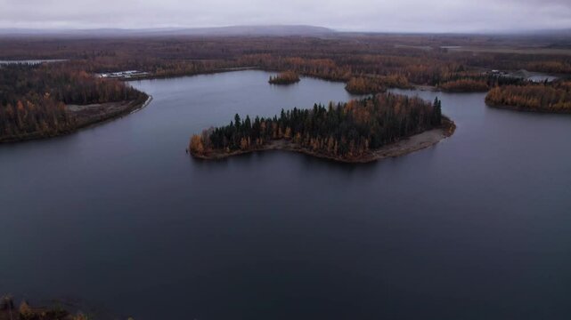 Drone aerial of an island with fall colors on the trees at Chena Lake, Alaska