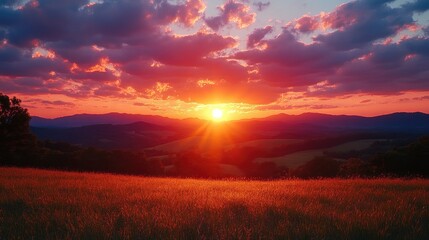 Fototapeta premium Vibrant sunset illuminating rolling hills and meadow