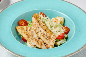 Classic Caesar Salad with Chicken Fillet on Blue Plate - Vibrant and Crisp Presentation