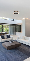 Fototapeta premium A contemporary living room showcases a clean design with two white sofas and a wooden coffee table