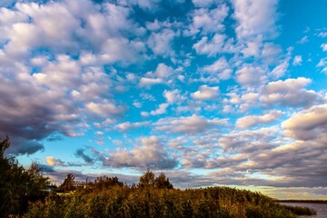 Bright Sky with Fluffy Clouds and Green Landscape