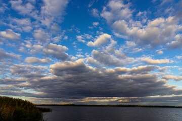 Dramatic Sky and Calm Water at Sunset — A Tranquil Riverside Scene