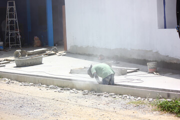 worker is repairing concrete drainage channel in construction site