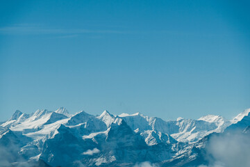 Obraz premium Snowy mountain view under a bright blue sky.