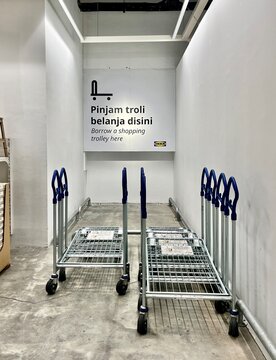 Jakarta, Indonesia - October 30th, 2024 - Shopping cart trolley metal objects in IKEA store Mall Taman Anggrek isolated on vertical ratio indoor environment background.