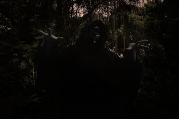 Grim reaper standing over dark forest and tree, Halloween mystery concept