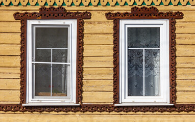Two windows with lace curtains and a wooden frame