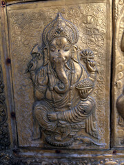 A gold statue of the god Ganpati with a large head and a small body