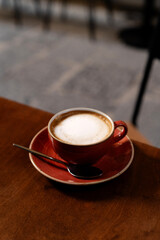 Top view of ceramic cup with cappuccino on the table