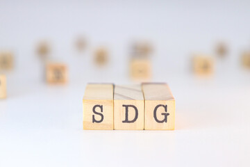 Sustainable Development Goals - SDG acronym written on wooden cubes isolated on white background with copy space.