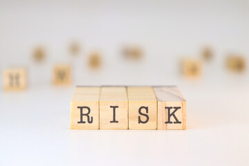 The word risk written on wooden cubes isolated on white background with copy space for text.