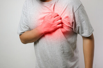 Young man has chest pain, heart attack, hands pressing on chest.