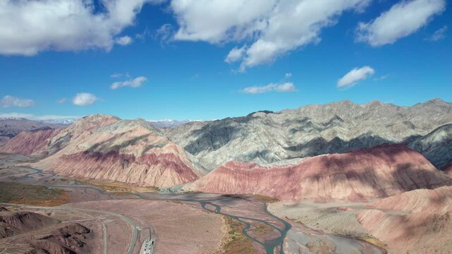 Drone view of Yadan landform near Kashgar in southern Xinjiang, China. High angle view of colorful mountains in sunny autumn day, 4k fast motion time lapse landscape footage b roll establishing shot.