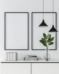 Minimalist interior design with two empty frames. hanging lamps. potted plant. books. and a decorative box on a white cabinet against a white wall