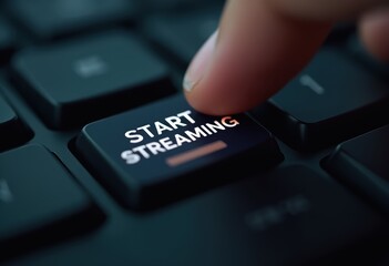 Close-up of a finger pressing a "Start Streaming" button on a keyboard