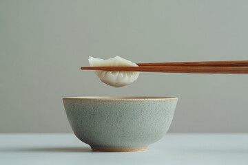 A chinese steamed dumpling held with chopsticks