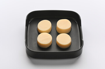 Egg Tofu in black melamine tray on white background.
