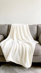 Cozy soft fleece blanket draped elegantly over a couch, perfect for warm, inviting living spaces.