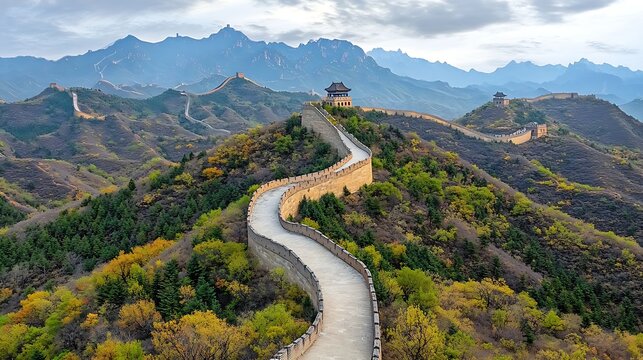 Aerial perspective of the winding path of the Great Wall of China as it meanders through rolling hills and valleys covered in fresh spring foliage.