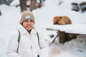 Woman tourist with Cute fox on snow in winter season at Zao fox village, traveler sightseeing...