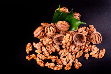 Four whole walnuts in the shell laid out in a row on a black background