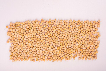 Chickpeas, raw and uncooked. Chickpea or garbanzo bean background. Full body photo of dry yellow colored shelled garbanzo beans. Close up view of chickpeas for cooking or health food concept