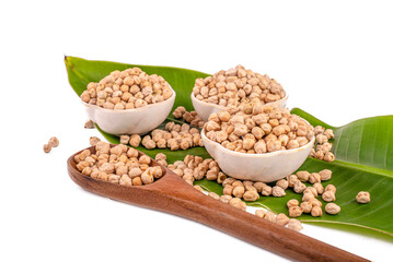 Dried chickpeas in white bowl on white. Spilled chickpeas.