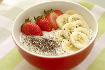 Editorial photo of oatmeal bowl with bananas, strawberries, and chia seeds