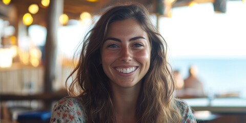Joyful American Woman Smiling at a Beachside Café Embracing the Sun and Sea Breeze