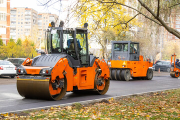 Compacting a new asphalt layer with rollers. Vibratory rollers and pneumatic-tyred rollers in operation.