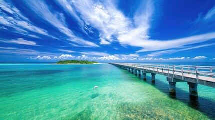 Obraz premium Scenic tropical vista featuring a turquoise ocean under a blue sky with wispy clouds on a summer day A long bridge leads to an island while a heron strides in the foreground amidst clear waters