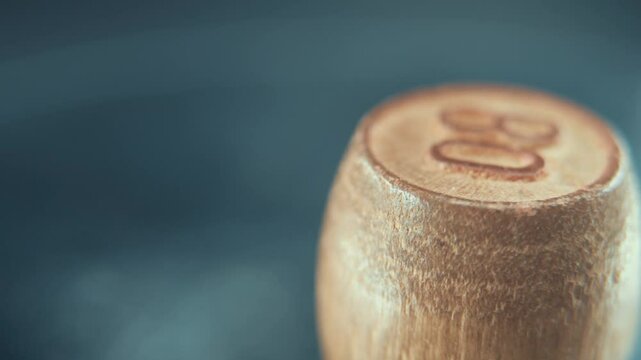 Macro steady shot of Bingo wooden barrel on a rotating stand, rotating 360, lucky number 80, board game, 4K
