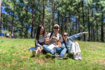 Fototapeta premium Three Young Friends Hiking in Nature Forest Happy looking for directions Trekking in National Park
