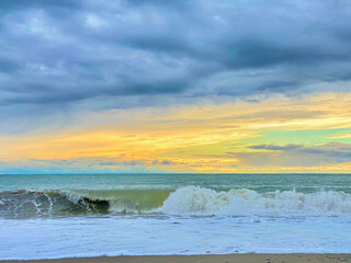 Beautiful sunset on the beach. The sea and sky with clouds.