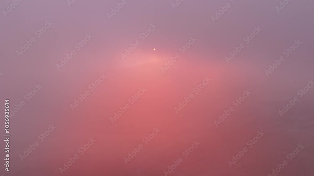 Aufkleber sunlight breaking through dense clouds over a misty mountain range, creating a serene and ethereal v