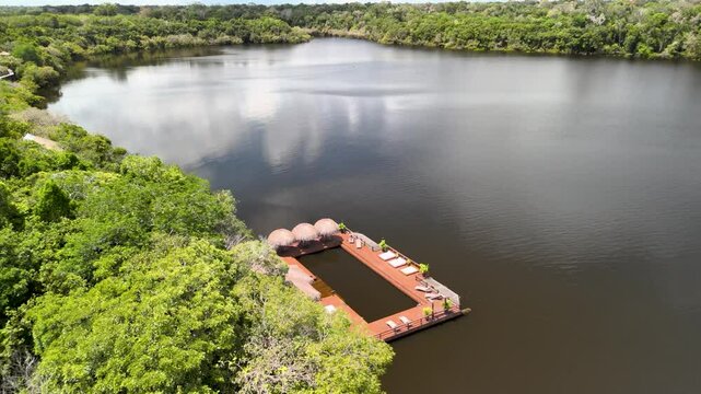 Drone reveals remote jungle lodge on Juma Rio with endless green horizon in Amazonas, Brazil