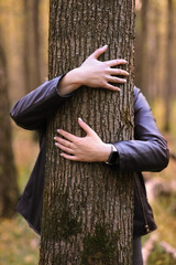 Arms hug the tree. Funny creative photo in the forest.