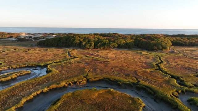 Bird's eye view of the vast salt marshes near Cape Cod with the bay in the distance.