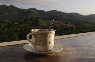 empty coffee cup on mountain nature landscape background. Good luck in drinking coffee