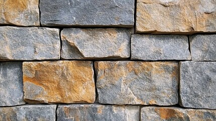 Fototapeta premium Patterned stone wall displays age-old rugged textures that offer an insight into the enduring nature of materials with a sense of history and steadfastness.