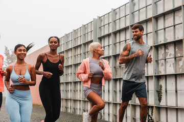 Athletes running together in the city on a cloudy day