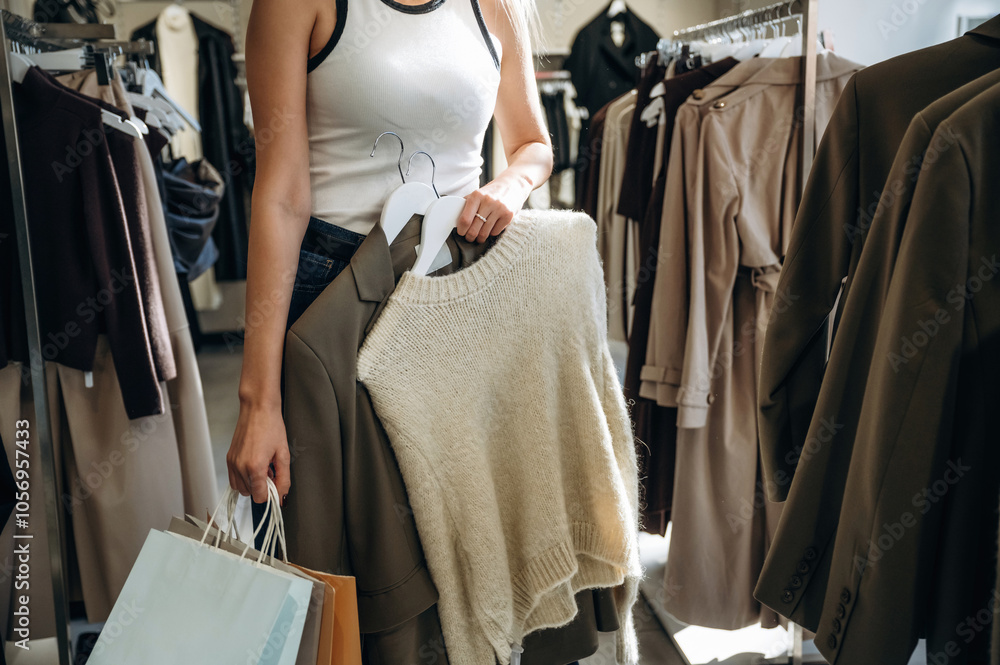 Wall mural shopping bags in hand. close up view of woman that is chooses clothes in the retail shop